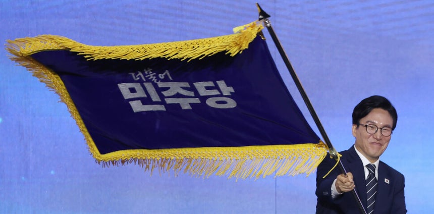김민석 더불어민주당 신임 당 대표가 17일 대전 컨벤션센터에서 열린 제3회 정기전국당원대회에서 당 대표로 선출된 뒤 당기를 흔들어 보이고 있다. 연합뉴스
