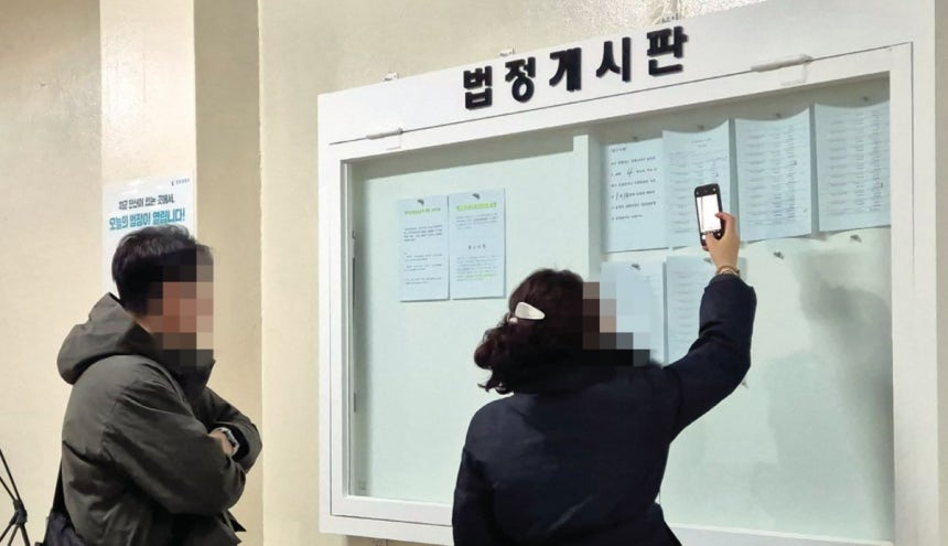 12월 3일 오전 서울중앙지법에서 매각기일 공고를 보고 있는 응찰자들.윤채원 기자