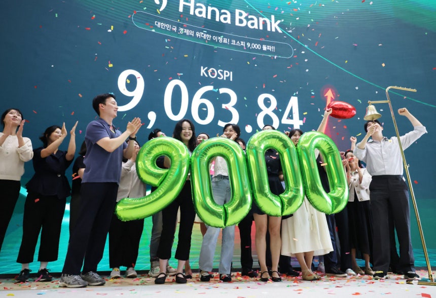 코스피가 사상 처음으로 9000을 돌파한 6월 18일 서울 중구 하나은행 딜링룸에서 직원들이 축하 세리머니를 하고 있다.뉴스1