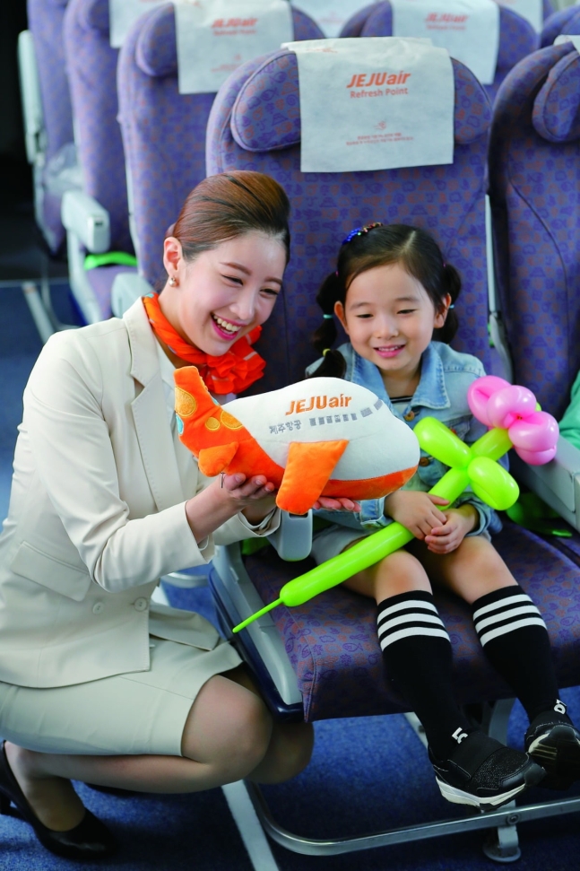제주항공 승무원이 어린이 승객에게 기념품을 전달하고 있다.  사진=제주항공