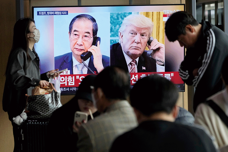 지난 4월 9일 서울역에서 시민들이 한덕수 대통령 권한대행 겸 국무총리와 도널드 트럼프 미국 대통령의 전화 회담 소식을 전하는 뉴스를 보고 있다.photo 뉴시스