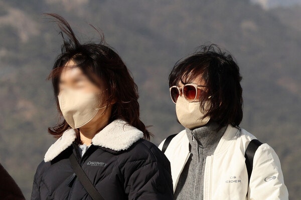 황사 영향으로 미세먼지 경보가 내려진 22일, 서울 광화문광장에서 관광객들이 마스크를 쓴 채 이동하고 있다. photo 뉴시스