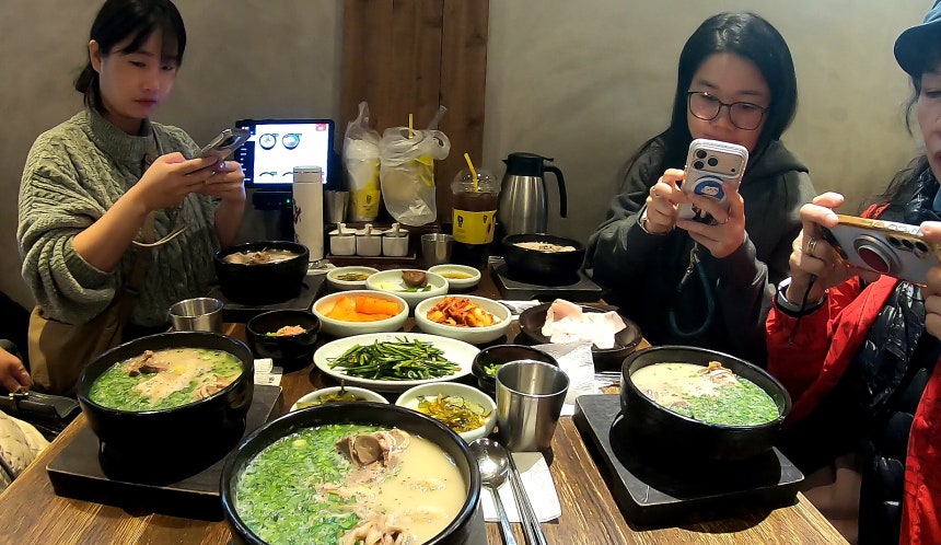 타이완 관광객 일행이 부산의 한 돼지국밥 식당에서 주문한 음식을 사진에 담고 있다.