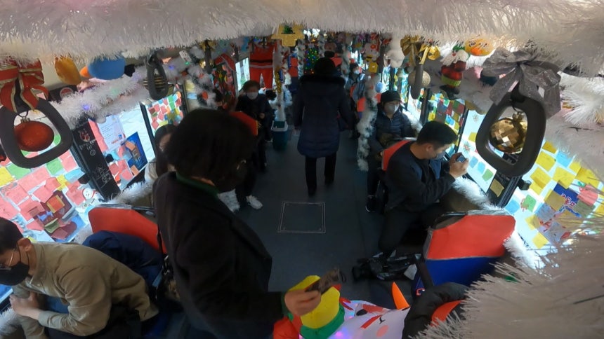 시민들이 버스 곳곳의 장식물과 포스트잇 등을 구경하고 있다