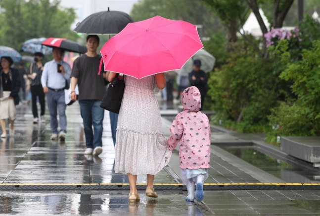 오늘(26일) 오후 비가 내리는 서울 광화문광장에서 시민들이 우산을 쓴 채 걸어가고 있다. / 사진 = 연합뉴스