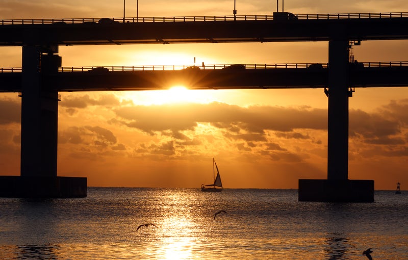을사년 2025년이 며칠 남지 않은 가운데 23일 부산 수영구 광안대교 위를 달리는 차량 너머 구름 사이로 해가 떠오르고 있다.2025.12.23 / 사진=연합뉴스