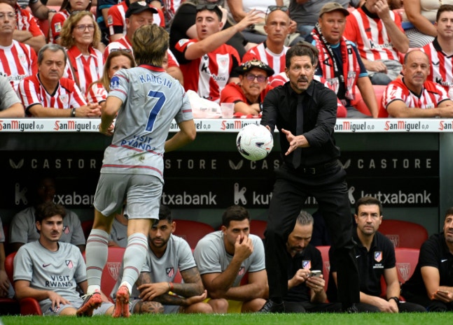 Atletico Madrid's Argentine coach Diego Simeone throws the ball to Atletico Madrid's South Korean midfielder #07 Kang-In Lee during the Spanish league football match between Athletic Club Bilbao and Club Atletico de Madrid at San Mames Stadium in Bilbao on September 5, 2026. (Photo by ANDER GILLENEA