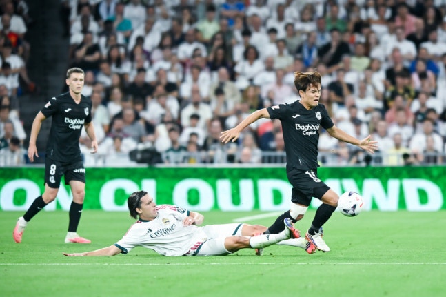 (260827) -- MADRID, Aug. 27, 2026 (Xinhua) -- Real Madrid's Alvaro Carreras (down) vies with Real Sociedad's Kubo Takefusa during a La Liga football match between Real Madrid and Real Sociedad at Santiago Bernabeu stadium in Madrid, Spain, on Aug. 26, 2026. (Photo by Gustavo Valiente/Xinhua)
