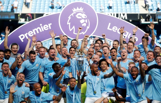 FILE PHOTO: Soccer Football - Premier League - Manchester City vs Huddersfield Town - Etihad Stadium, Manchester, Britain - May 6, 2018 Manchester City manager Pep Guardiola celebrates with the trophy, players and staff after winning the Premier League title Action Images via Reuters/Carl Recine EDI