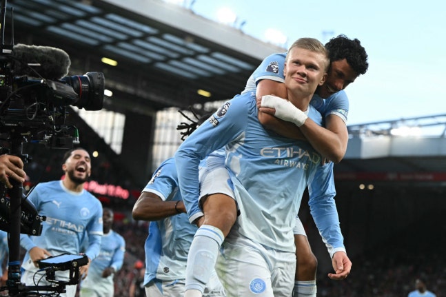 Manchester City's Norwegian striker #09 Erling Haaland celebrates with Manchester City's Portuguese midfielder #27 Matheus Nunes (R) after scoring the opening goal during the English Premier League football match between Liverpool and Manchester City at Anfield in Liverpool, north west England on Oc