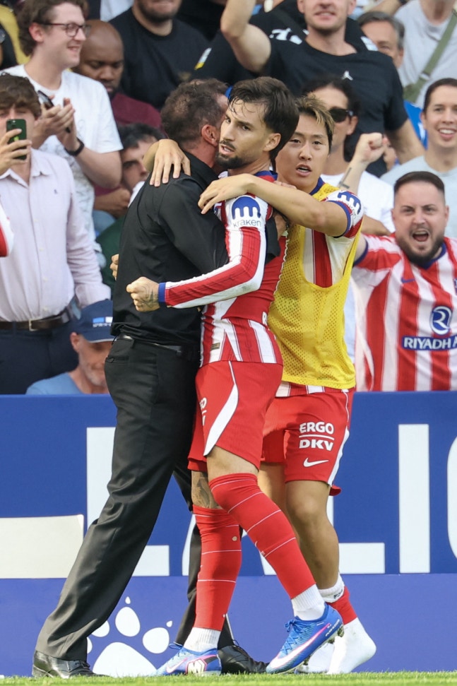 Atletico Madrid's Spanish forward #10 Alex Baena (C) celebrates scoring his team's first goal with Atletico Madrid's Argentine coach Diego Simeone during the Spanish league football match between RCD Espanyol and Club Atletico de Madrid at RCDE Stadium in Cornella de Llobregat on October 17, 2026. (