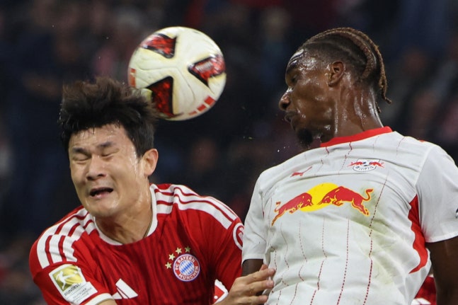 Bayern Munich's South Korean defender #03 KimaMin-Jae (L) and Leipzig's Dutch midfielder #06 Ezechiel Banzuzi both jump to head the ball during the German first division Bundesliga football match between FC Bayern Munich and RB Leipzig in Munich, southern Germany, on October 17, 2026. (Photo by Alex