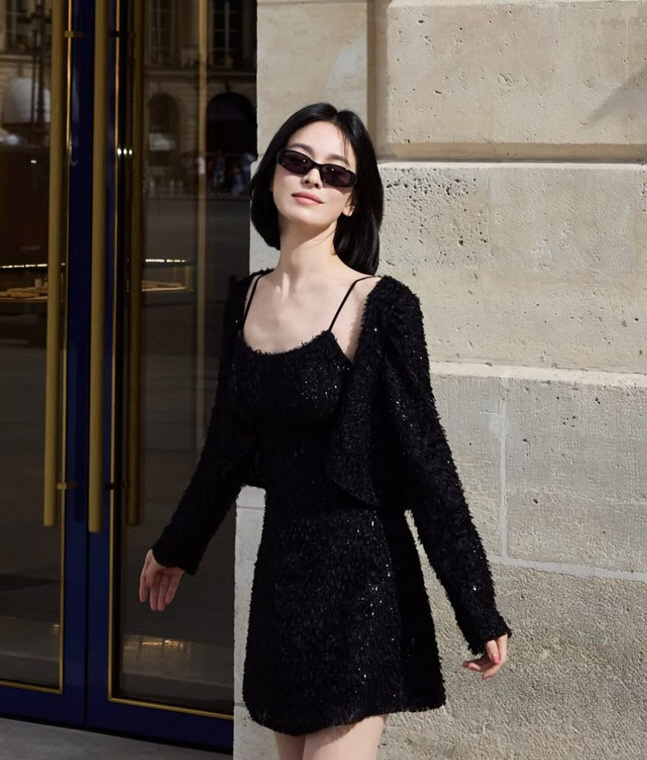 パリの建物の前で、黒いドレスとカーディガンにサングラスを合わせたソン・ヘギョ