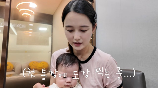 YouTube動画で、生後2か月ごろの息子を抱いて初めての通帳を記念撮影するナム・ボラ