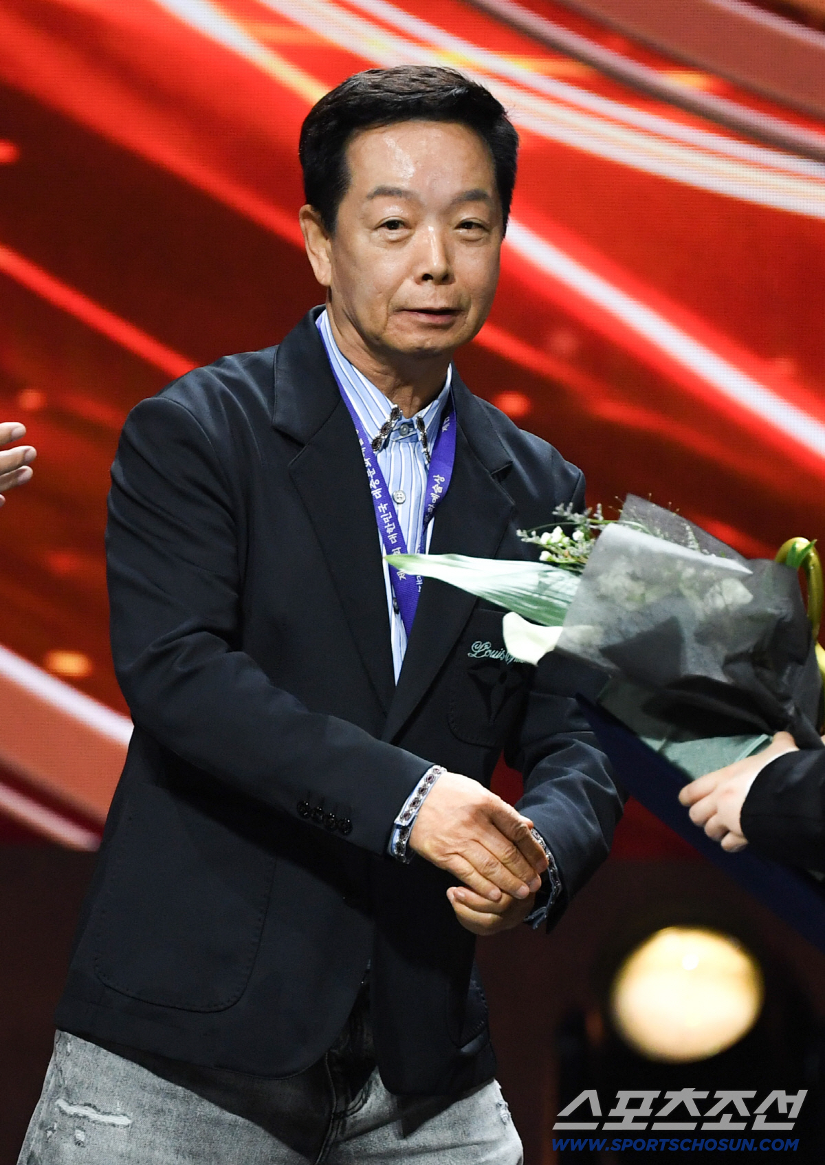 第17回大衆文化芸術賞の会場で、濃紺のジャケット姿で花束を持つキム・ハクレ