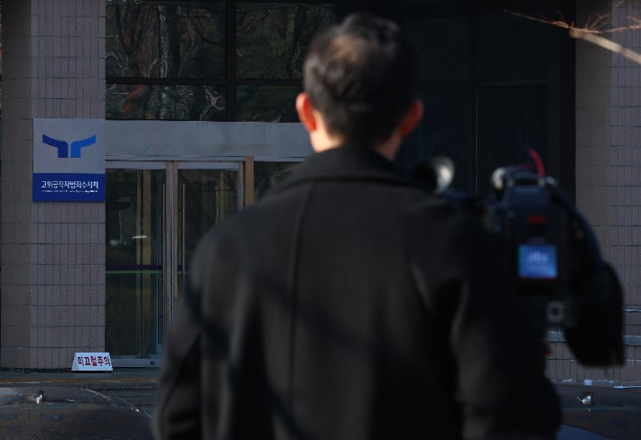 A broadcast journalist waits outside the High-Ranking Public Officials Crime Investigation Office in Gwacheon Government Complex on the morning of the 17th. Yonhap News