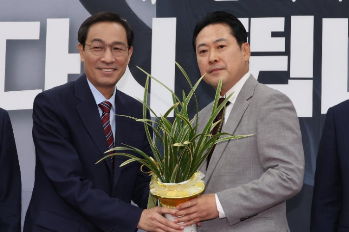 우상호 대통령실 정무수석이 27일 서울 여의도 국회에서 국민의힘 장동혁 신임 대표를 예방해 이재명 대통령이 보낸 축하난을 전달하는 모습. 연합뉴스