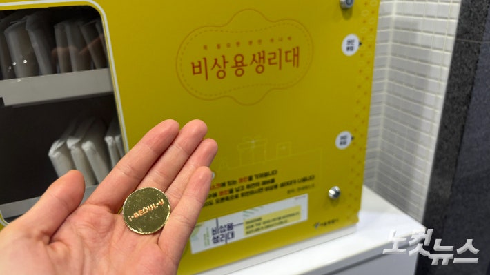 19일 서울 중구 서울도서관 여자 화장실에 비치돼있는 '비상용 생리대 자판기'.사진처럼 안내데스크에서 코인을 받아 자판기에 넣으면 생리대가 나온다.김수정 기자