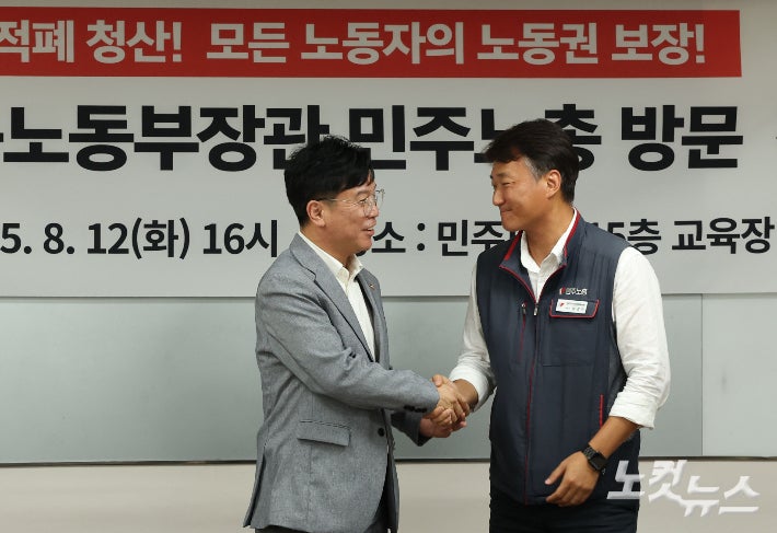 김영훈 고용노동부 장관이 지난 8월 12일 서울 중구 전국민주노동조합총연맹(민주노총)을 찾아 양경수 민주노총 위원장과 기념촬영을 하고 있다.류영주 기자