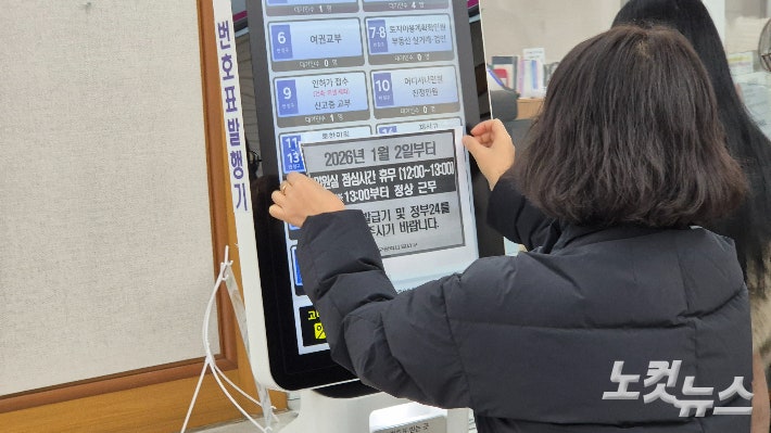 2일 오전 11시 50분쯤 대구 달서구청 종합민원실에서 한 공무원이 번호표 발행기에 점심시간 휴무제 안내문을 붙이고 있다.곽재화 기자