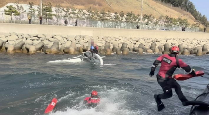 포항해경 구조대가 전복된 딩기 요트 탑승자를 구조하기 위해 바다에 입수하고 있다. 포항해경 제공