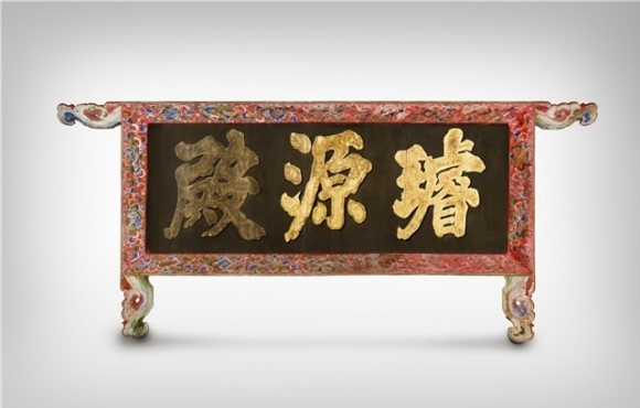 일본에서 환수된 경복궁 선원전 편액. 옻칠(흑칠)을 한 바탕판에 금빛 글씨가 새겨져 있다. 테두리를 연장한 봉에는 구름무늬를 조각하고 테두리에는 부채, 보자기 등 보물 문양을 그려 넣는 등 격조 높은 현판 양식을 보