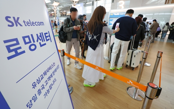 인천국제공항 출국장에 늘어선 유심 교체 대기 행렬&#8194;4일 인천국제공항 제1여객터미널 출국장에 마련된 SK텔레콤 로밍센터에서 유심을 교체하려는 출국 예정자들이 줄을 서고 있다.연합뉴스