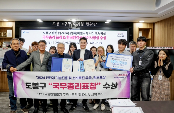 오언석(앞줄 왼쪽 네 번째) 서울 도봉구청장과 직원들이 지난해‘친환경 기술진흥 및 소비촉진 유공 정부포상’에서‘국무총리 표창’을 수상한 뒤 기념 촬영을 하고 있다.도봉구 제공