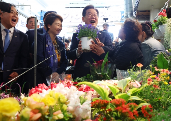 ‘영남 신라벨트 골목골목 경청투어’에 나선 이재명 더불어민주당 대선 후보가 10일 경남 함안군 가야전통시장의 한 꽃가게를 찾아 화분을 구매하며 밝게 웃고 있다. 2025.5.10 연합뉴스