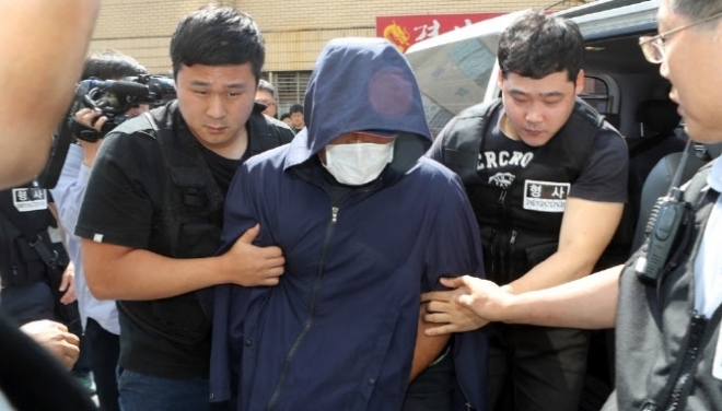 음악 소리가 시끄럽다며 아파트 옥상에서 밧줄을 잘라 노동자를 숨지게 한 서 씨가 현장 검증을 위해 경찰과 함께 이동하고 있다.  연합뉴스