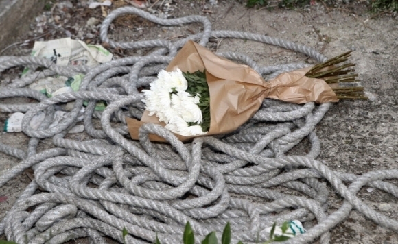 2017년 6월 주민이 밧줄을 잘라 근로자가 숨진 경남 양산 아파트 현장에 밧줄과 흰 국화가 놓여 있다.  연합뉴스