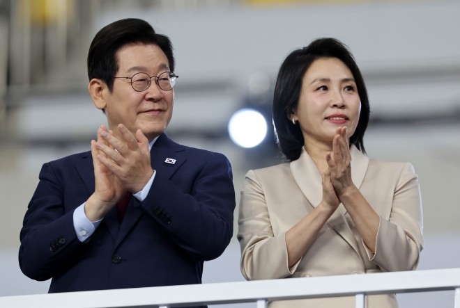 이재명 대통령과 김혜경 여사가 17일 오후 부산 연제구 부산아시아드주경기장에서 열린 제106회 전국체육대회 개회식에 참석해 입장하는 선수단에 박수를 보내고 있다. 뉴시스