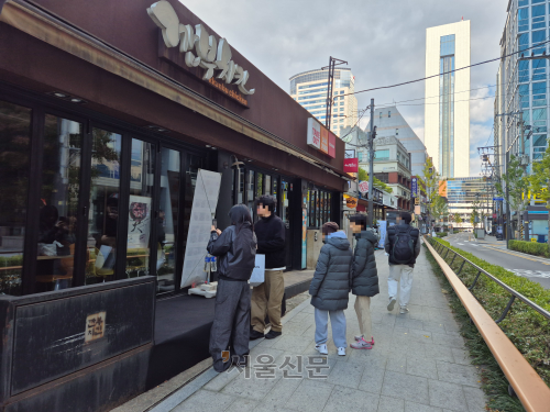 2일 시민들이 젠슨 황 엔비디아 최고경영자(CEO)와 이재용 삼성전자 회장, 정의선 현대차그룹 회장이 지난 30일 다녀간 서울 강남구 깐부치킨 삼성점을 찾아 기념 촬영을 하고 있다