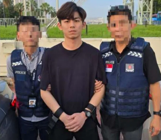 싱가포르 경찰이 캄보디아에서 활동하는 사기 조직과 관련 있는 것으로 의심하는 용의자 버나드 고 이 션의 신병을 확보한 후 함께 촬영한 사진. 싱가포르 경찰 제공