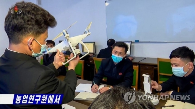 2023년 북한 농업 연구원이 중국 DJI 팬텀4로 추정되는 드론을 살펴보고 있는 모습.2023.1.24 [조선중앙TV 화면] 2023.1.24.연합뉴스