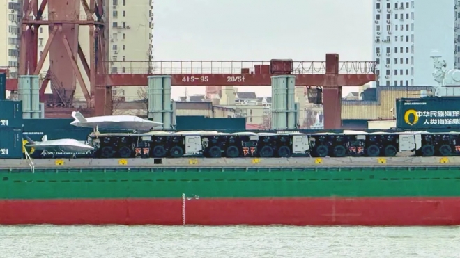 중국 상하이 후둥-중화 조선소에서 개조 중인 화물선 갑판 가장자리에 트럭형 전자기 사출기 모듈이 열차처럼 연결된 모습.여러 대의 차량이 하나의 사출 궤도를 형성하고 있지만,이 같은 분절형 구조가 실제 해상 환경에