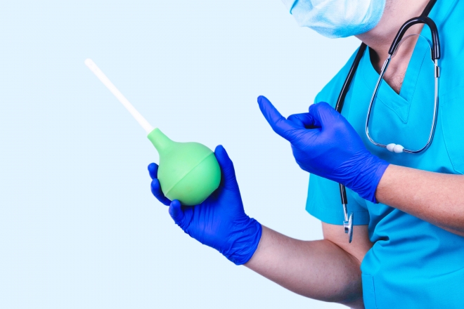 관장 기구를 들고 있는 의사.123rf