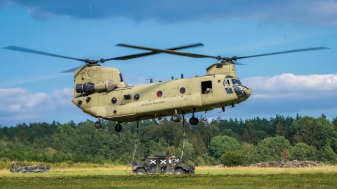 미 육군 CH-47 치누크가 외부 화물 수송 훈련을 위해 지상 차량을 와이어로 연결한 채 비행하고 있다.미 육군 제공