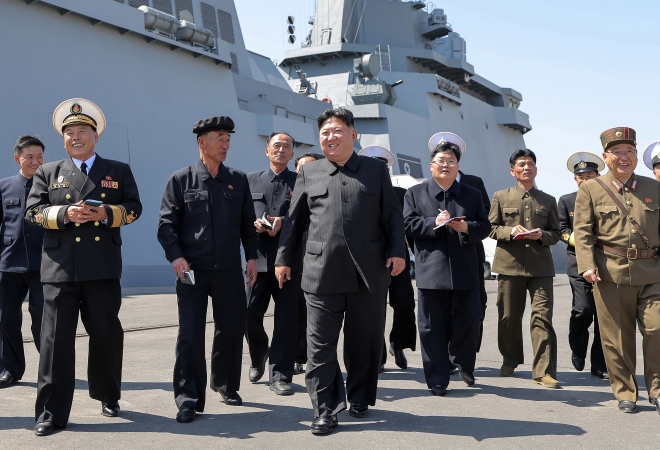 김정은 북한 국무위원장이 해군 간부들과 함께 취역을 앞둔 5000t급 신형 구축함 ‘최현호’를 둘러보고 있다. 조선중앙통신 연합뉴스