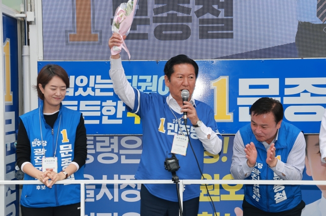 더불어민주당 정청래 총괄상임선거대책위원장이 28일 서울 광진구 건대입구역 앞 사거리에서 문종철 광진구청장 후보 지원 유세를 하는 가운데 한 시민으로부터 꽃다발을 받아 들어올려 보이고 있다. 2026.5.28. 연합뉴