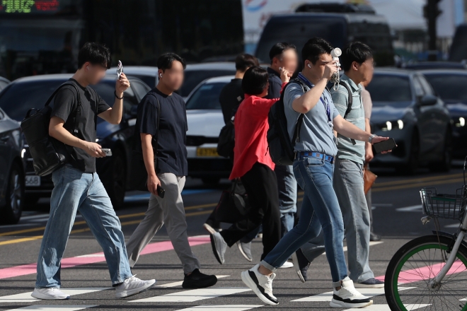 무더위가 이어진 29일 서울 중구 세종대로 사거리에서 시민들이 손으로 햇볕을 가리며 이동하고 있다.2026.07.29.뉴시스