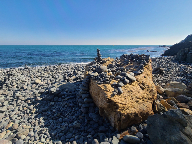 그린레일웨이 덱길에서 몽돌해변으로 이어지는 계단을 걸어 내려가면 약 200m 길이의 몽돌해변에 수박 만한 몽돌부터 구슬 정도 크기의 몽돌이 지천으로 깔려 있다. 몽돌로 쌓은 소원 탑이 곳곳에 보인다.