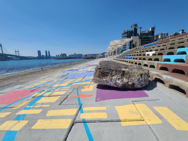 민락수변공원을 걷다 보면 커다란 갯바위가 덩그러니 놓여 있다. 태풍 때 바다에서 밀려 올라온 바위다. 자연 재해에 대한 경각심을 높이기 위해 바위를 그대로 두고 있다고 한다.