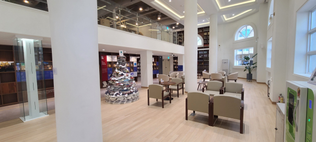 1층과 2층 사이 슬래브를 걷어낸 공간은 개방감이 느껴지면서 아늑하다. 깔끔한 호텔 로비를 찾은 듯하다. 편안한 의자들이 놓여 있고, 별관 개관을 기념해 책들을 탑 모양으로 쌓은 ‘시민의 책탑’도 자리한다.