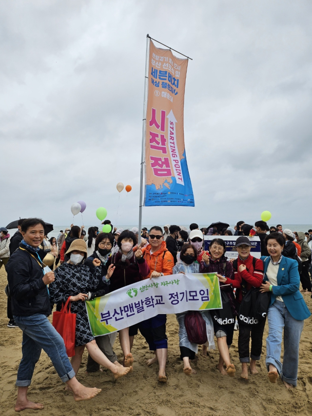 21일 부산 해운대해수욕장에서 진행된 세븐비치 어싱 챌린지 해운대 편에 참가한 대한민국맨발학교 부산지회 회원들이 출발지점에서 단체 사진을 찍고 있다. 대한민국맨발학교 부산지회 제공