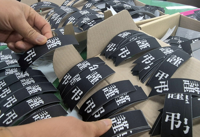 제주항공 참사 피해자를 추모하기 위한 근조 리본을 준비하고 있다. 연합뉴스