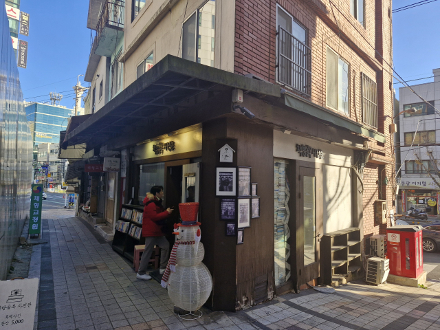 부산 중구 대청로 보수동책방골목 초입에 자리 잡은 책방골목사진관. 실제 운영하는 헌책방 안에서 추억의 흑백사진을 찍을 수 있다. 사진관 외벽에는 실제로 판매하는 헌책들이 꽂혀 있다. 사진 촬영이 진행 중일 땐 창문 