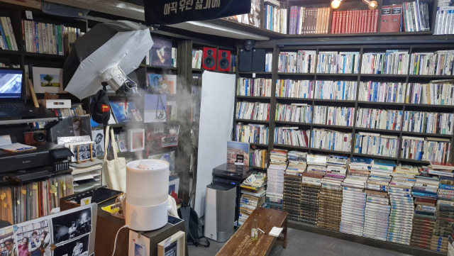 책방골목사진관 내부. 여느 헌책방처럼 책으로 빼곡히 채워진 책장과 바닥부터 쌓아 올린 책들이 눈길을 끈다. 사진의 배경이 되는 곳이다. 김희돈 기자