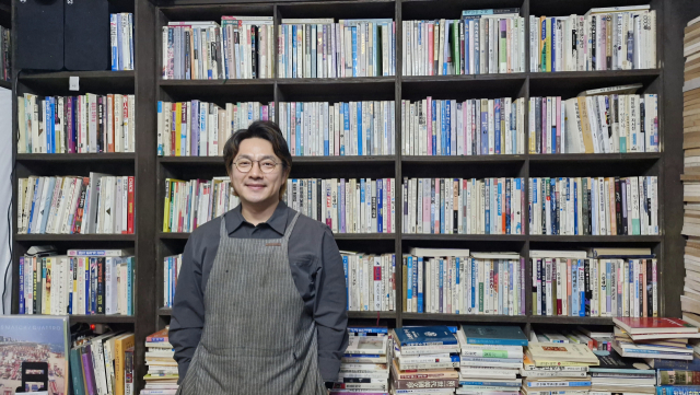 사진 배경이 되는 책장 앞에서 포즈를 취한 책방골목사진관 장호림 대표. 어릴 때 뛰어다니던 고향 마을에 돌아와 열었다. 김희돈 기자