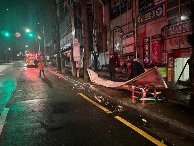 3일 오전 5시 19분 부산 해운대구의 한 가게 간판이 강풍으로 추락해 소방관이 사고 현장을 수습하고 있다.부산소방재난본부 제공